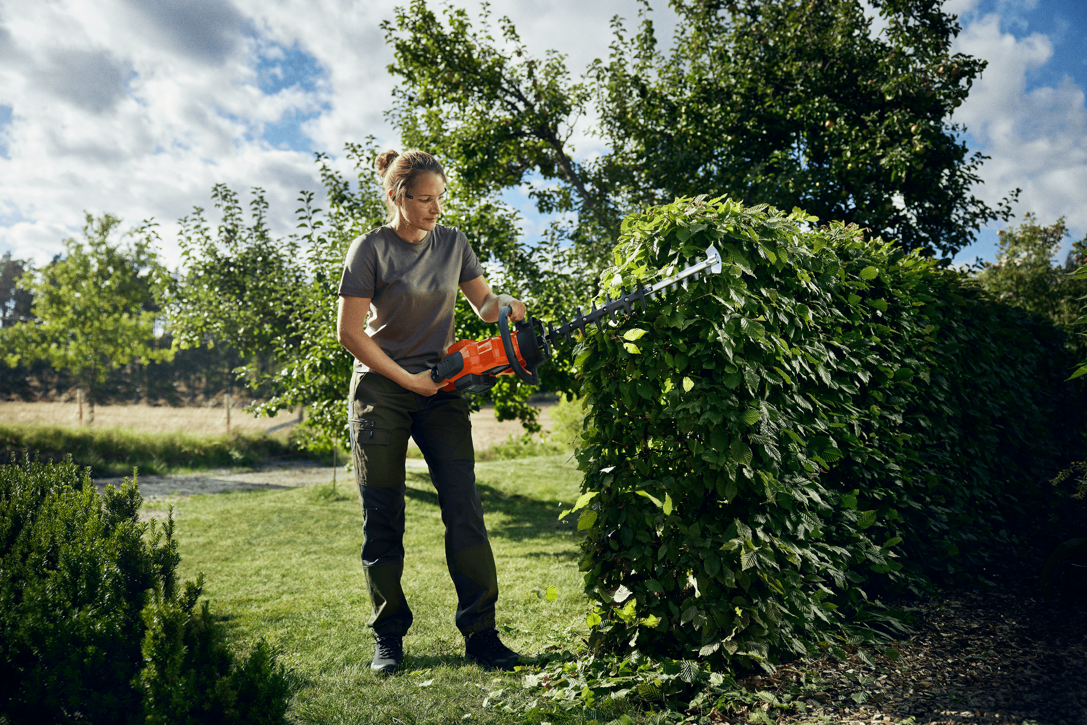 man holding polesaw whilst cutting tree